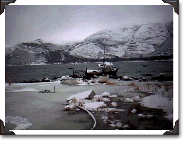 A derelict boat sits in Nain harbour under ever-watchful Mount Sophie.